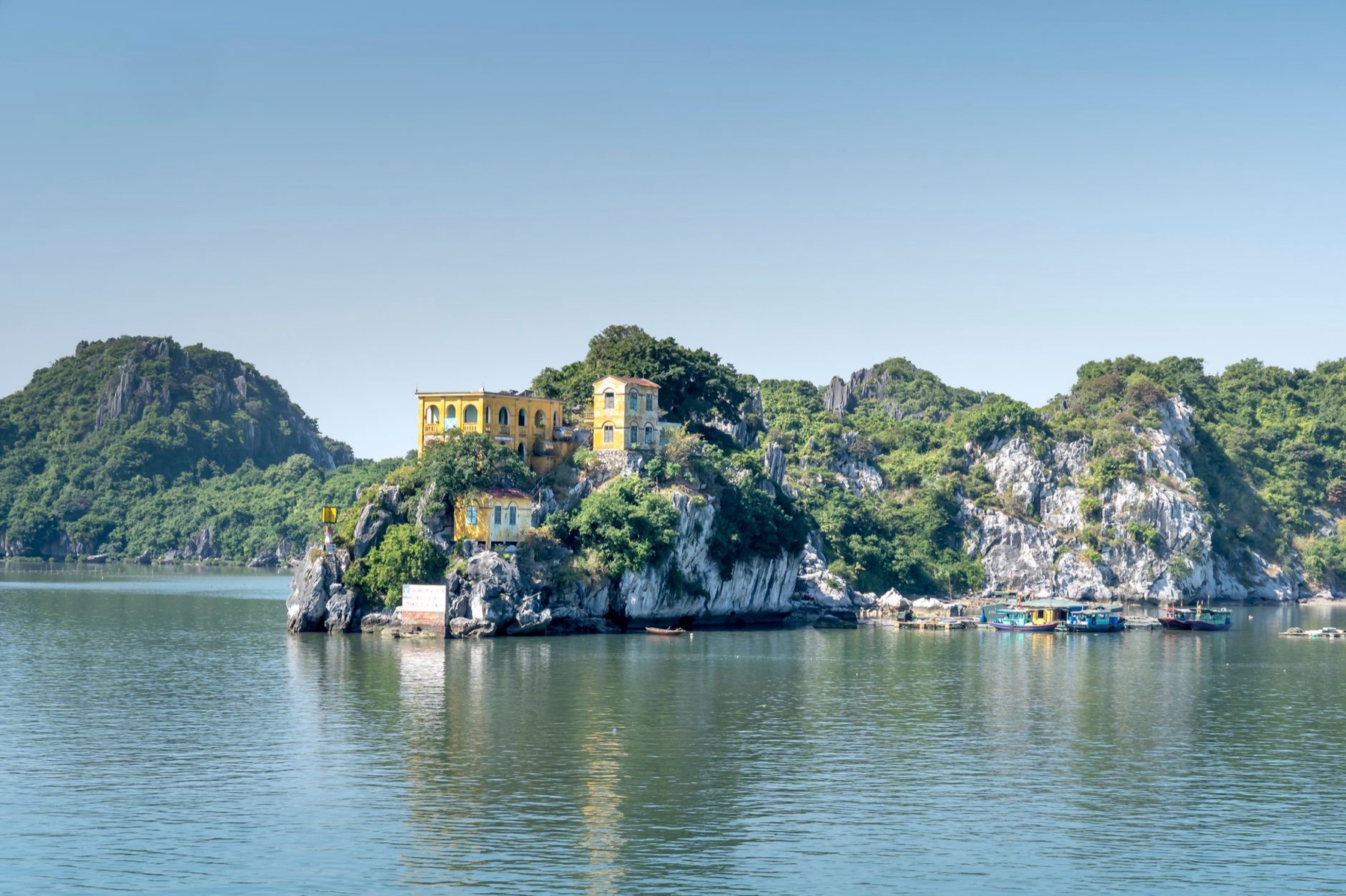 Cat Ba — Island villa perched on rocky cliffs of Cat Ba, Vietnam with calm sea and surrou