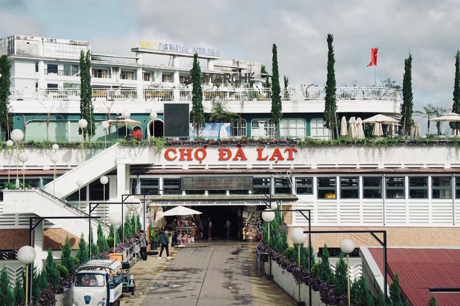 Da Lat — Vibrant scene of Da Lat market entrance with vendors in Vietnam.