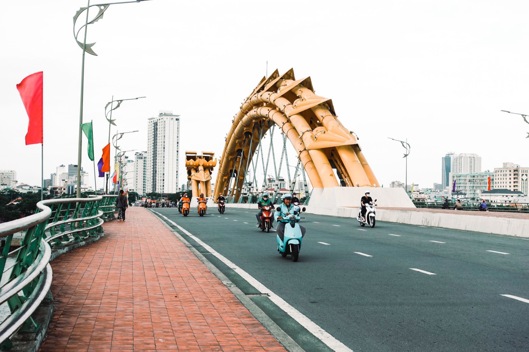 Da Nang — Motorbikes crossing the iconic Dragon Bridge in Da Nang, Vietnam on a clear day.