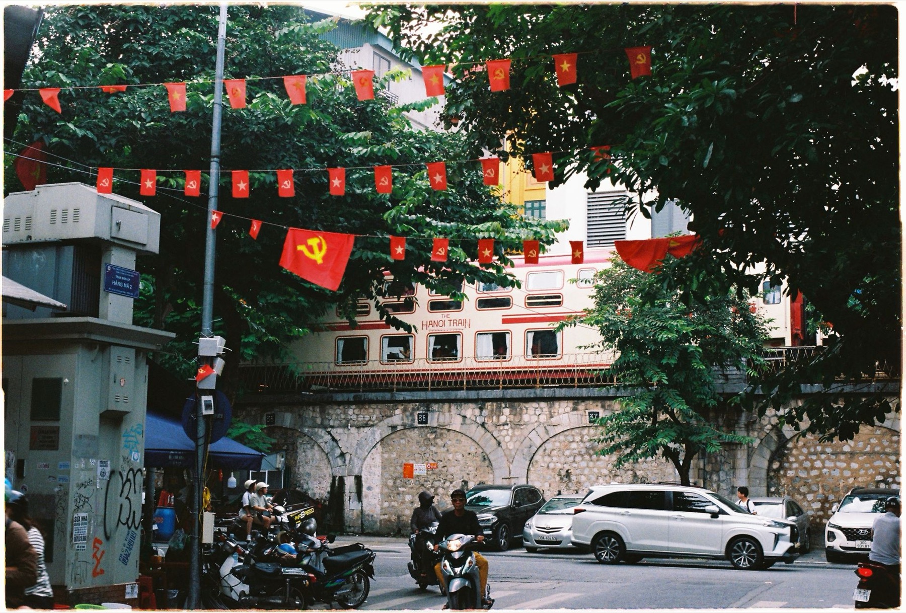 Hanoi — Hanoi train passes overhead in the Old Quarter, showcasing vibrant street life a