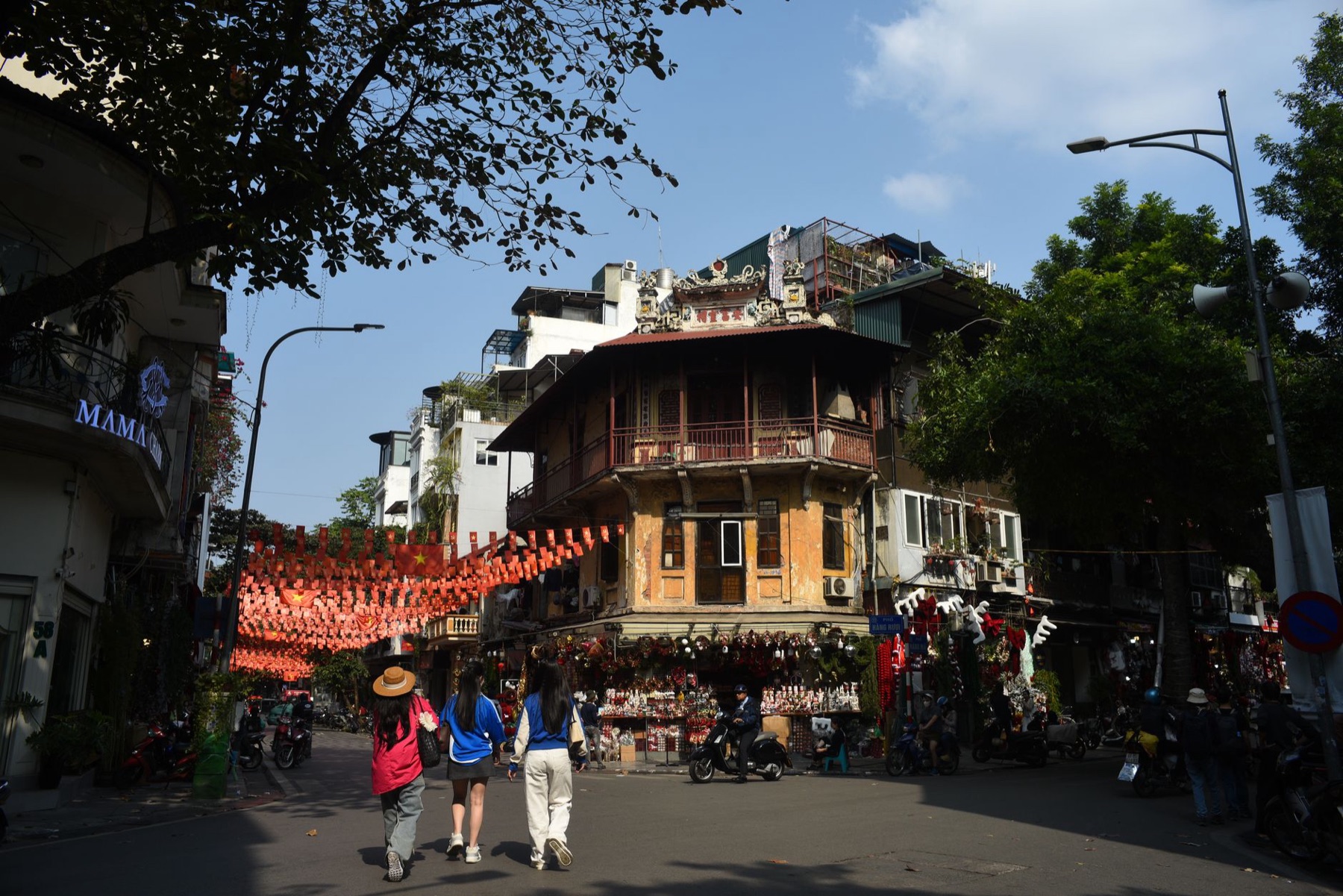 Hanoi — Vibrant scene of people walking through Hanoi's Old Quarter under festive decora