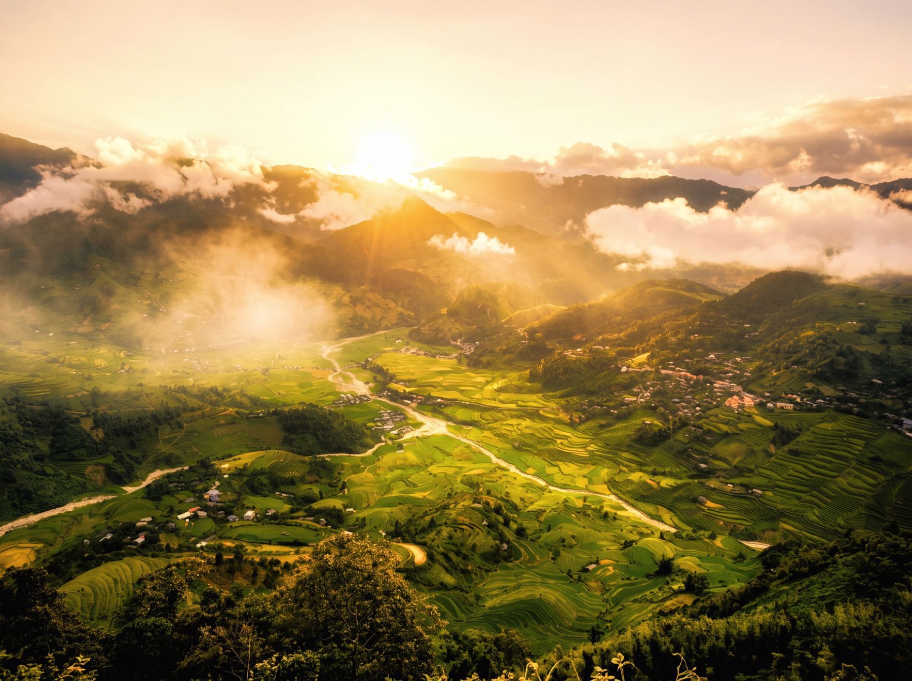 Mai Chau — Stunning aerial view of lush green valleys and terraced fields under a golden su