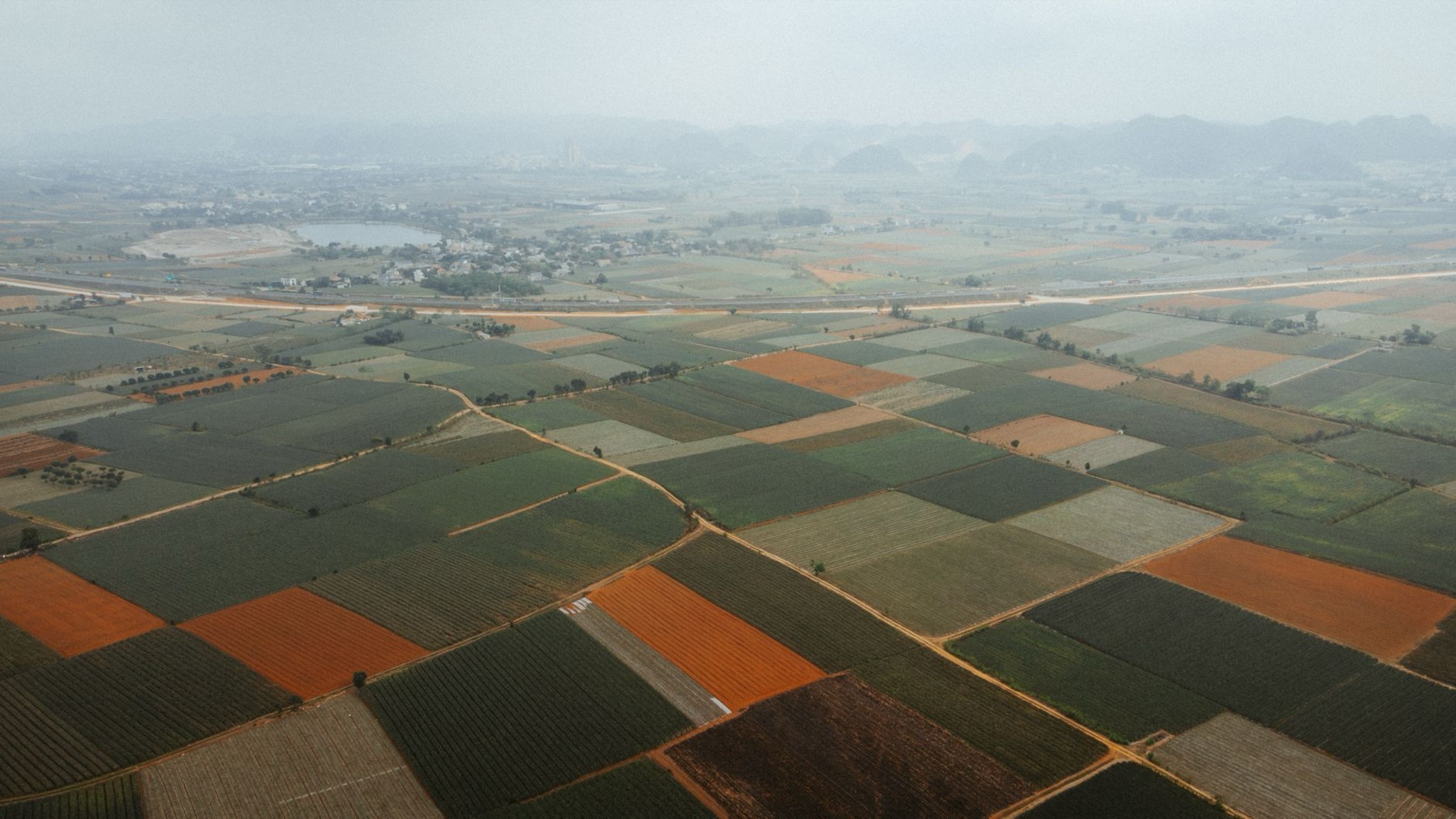 Mai Chau — Aerial view showcasing vast agricultural fields with diverse crops and geometric