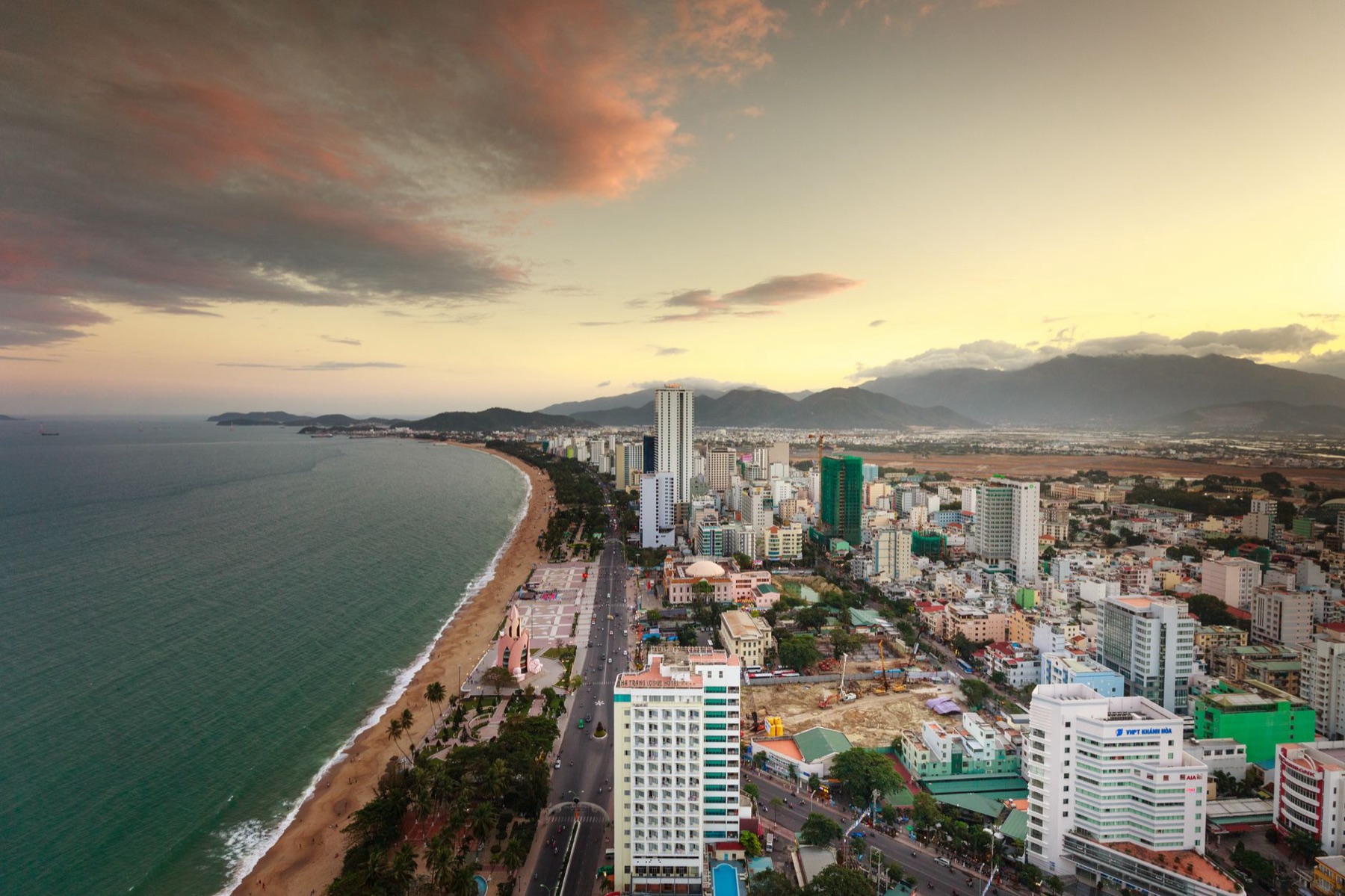 Nha Trang — A stunning aerial view of a coastal city at dawn with a vibrant skyline and scen