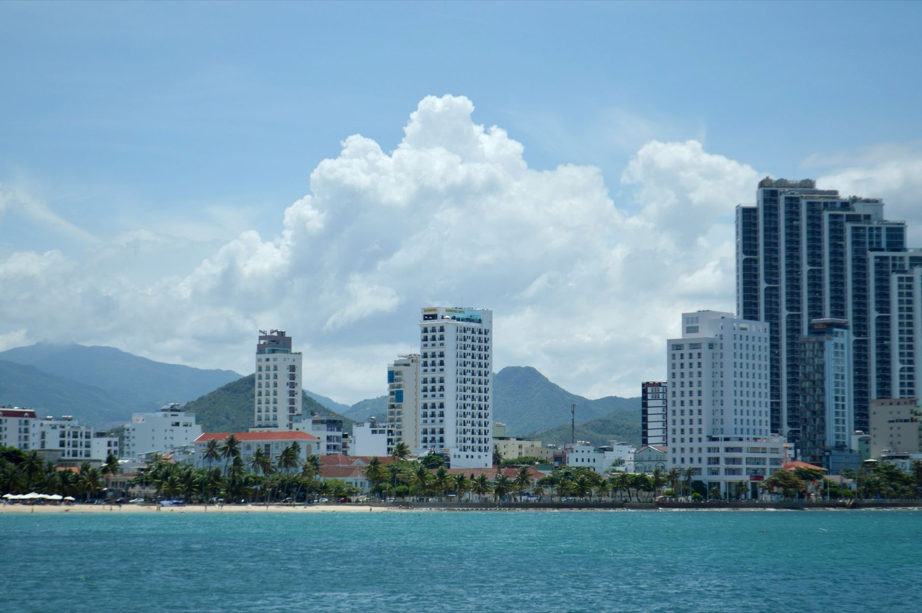 Nha Trang — A vibrant city skyline with tropical beachfront and mountain backdrop.