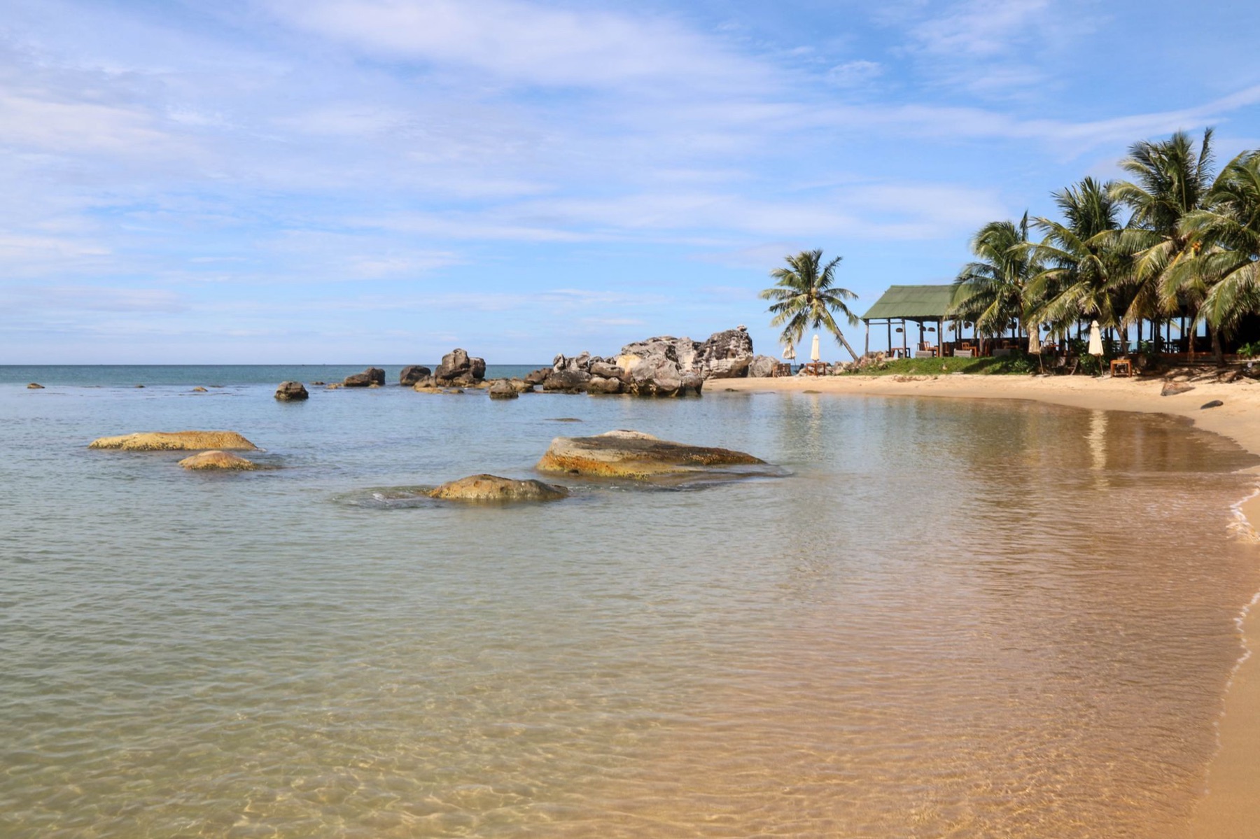 Phu Quoc — Serene beach landscape with palm trees, rocks, and clear water. Perfect tropical