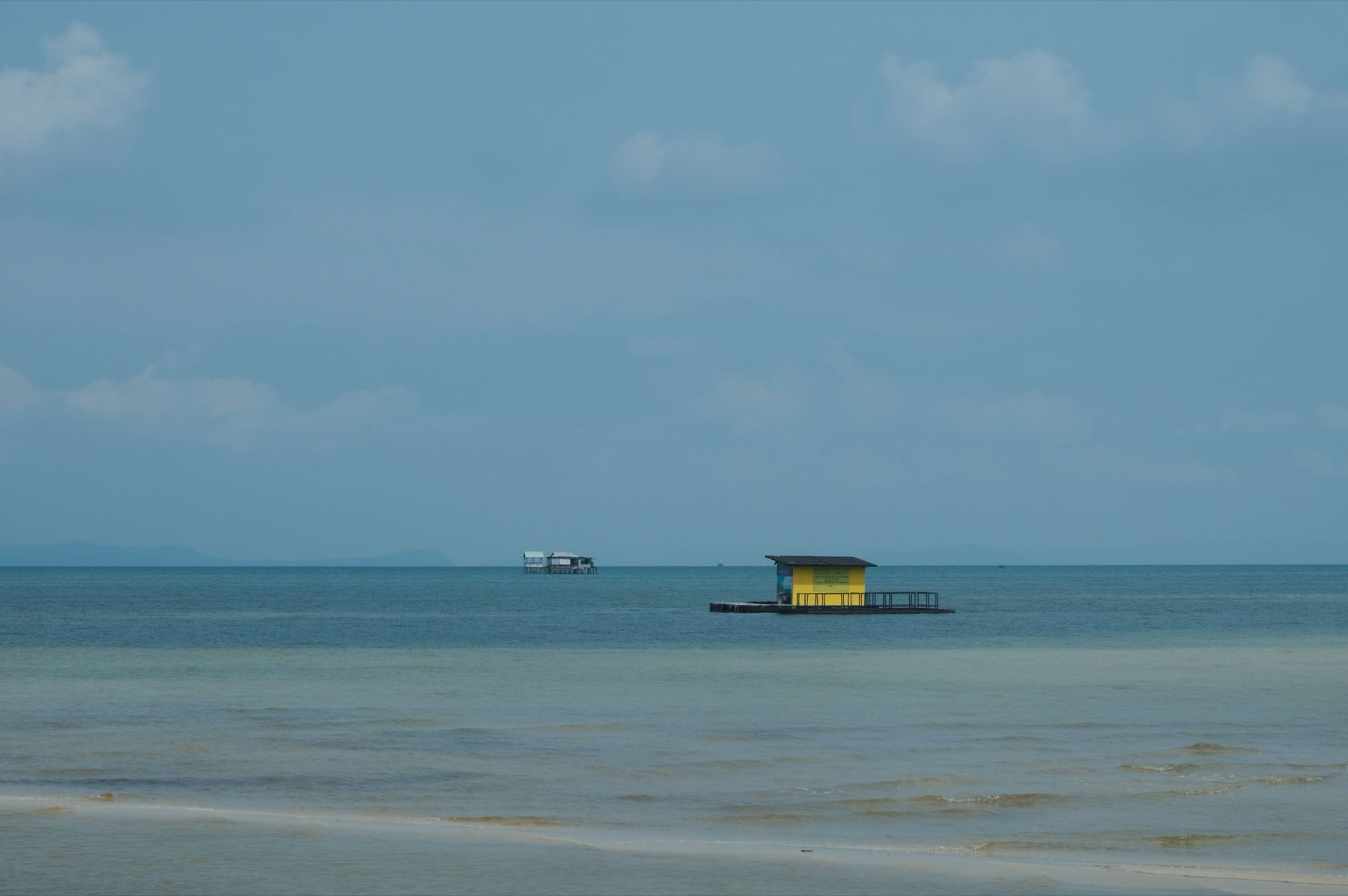 Phu Quoc — A serene view of a yellow floating house on the tranquil Phu Quoc beach in Vietn