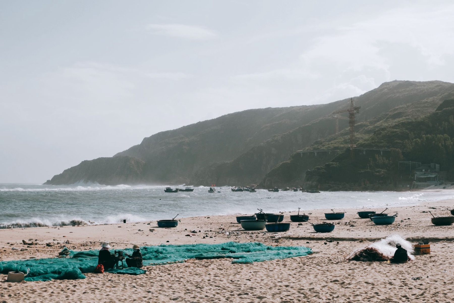 Quy Nhon — Serene beach scene with traditional fishing boats in Qui Nhơn, Việt Nam, under a