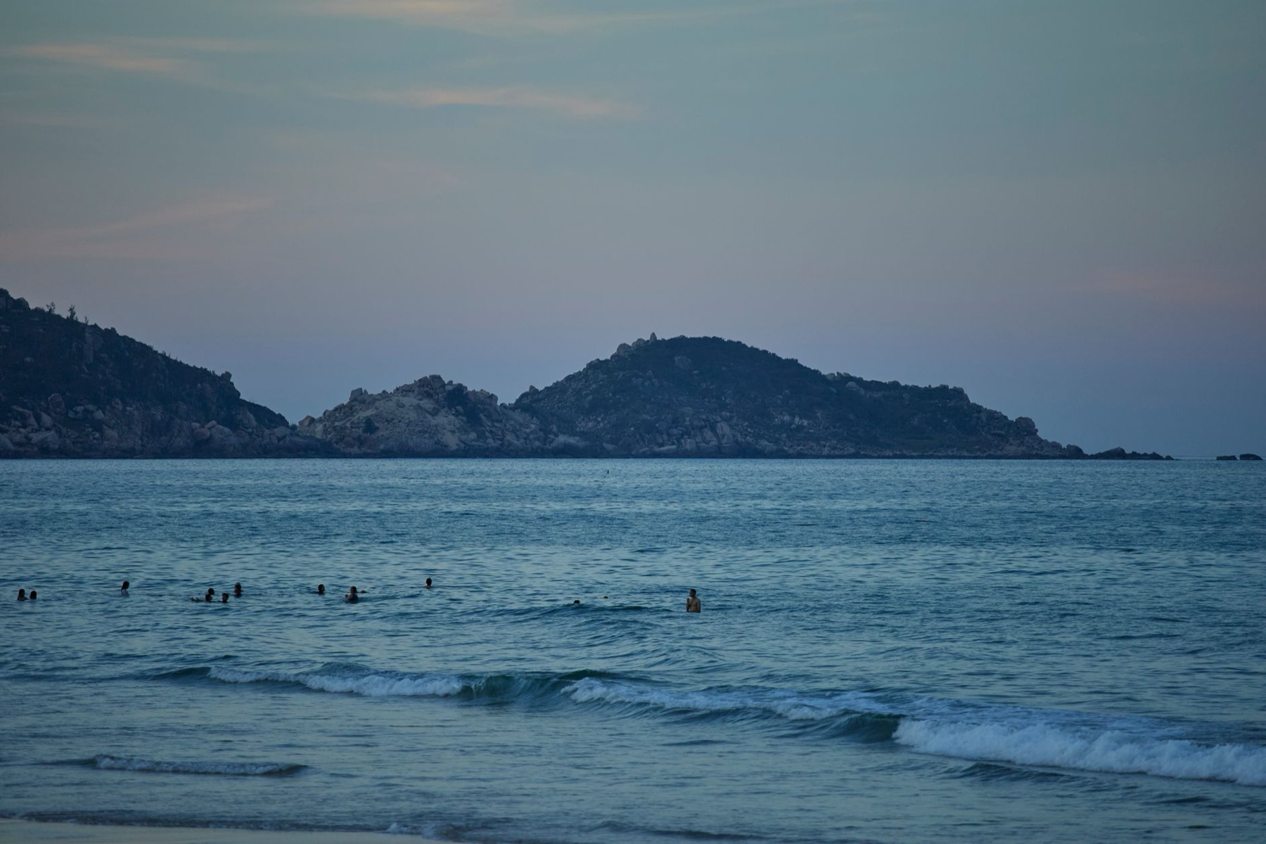 Quy Nhon — Swimmers enjoy a calm evening in the serene waters of Quy Nhon Beach, Vietnam.